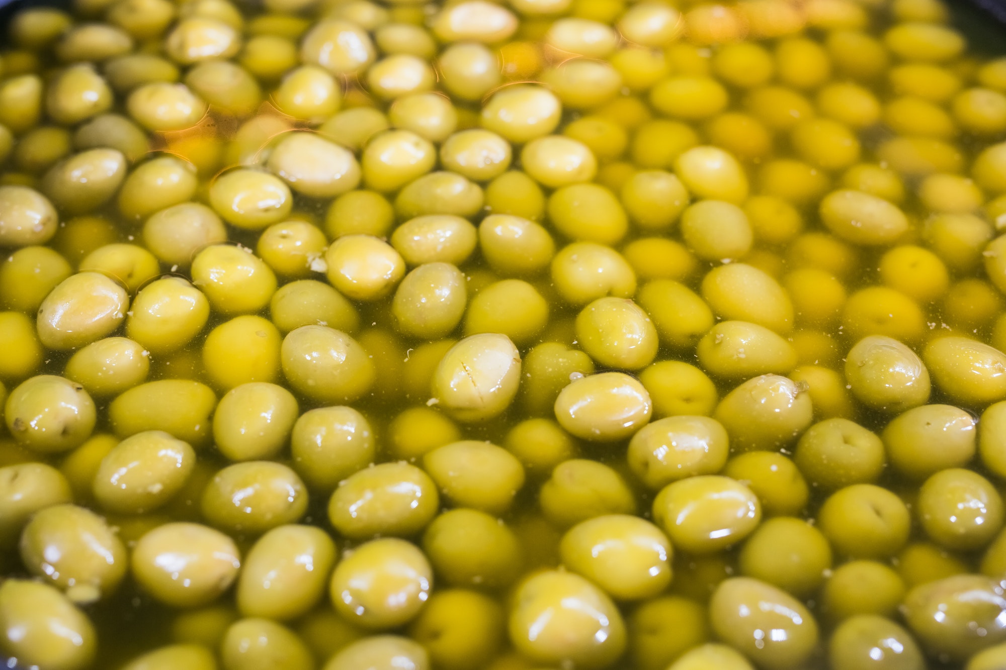 A lot of fresh green olives in a bowl